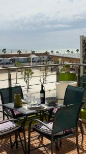 a table and chairs on a balcony with a view of the beach at Rivage hyper centre et plage a pied in Le Barcarès