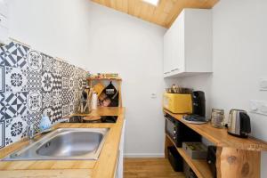 a kitchen with a sink and a counter top at L'Envol - Oasis Ressource in Eyliac