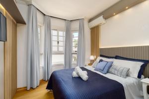 a bedroom with a blue and white bed and a window at Apto bem no Centro 2 dorm by Achei Gramado in Gramado +20 photos