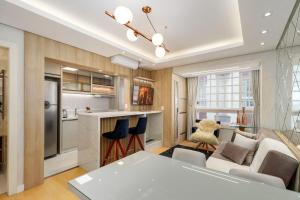 a kitchen and living room with a couch and a table at Apto bem no Centro 2 dorm by Achei Gramado in Gramado