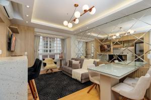 a living room with a table and a couch at Apto bem no Centro 2 dorm by Achei Gramado in Gramado