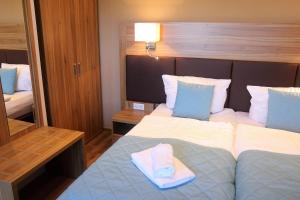 a hotel room with a bed with a towel on it at Sporthotel Dorum in Dorum