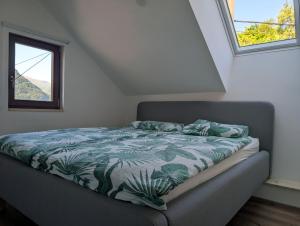 a bed sitting in a room with a window at Apartmaji Pippi in Bovec