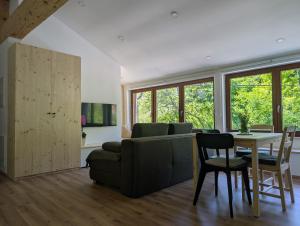 a living room with a couch and a table and chairs at Apartmaji Pippi in Bovec