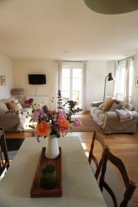 a living room with a table with a vase of flowers on it at Lerchenhof in Balingen