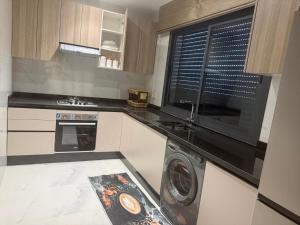 a kitchen with a washing machine and a window at tanger in Oulad Akkou +6 photos