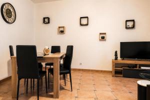 a dining room with a table and chairs and a tv at Le Saint-Roch Issoudun - Charm & Private Terrace in Issoudun +2 photos