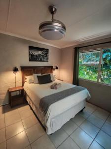 a bedroom with a large bed and a large window at Ikaya Accommodation PSJ in Port St. Johns