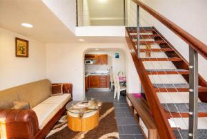 a living room with a couch and a staircase at Apartments Duplex Oliva in Trebinje