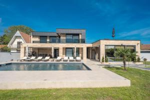 a house with a swimming pool in front of it at Vila Lux in Tešanovića Mala