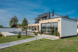 a house with a pool and a yard at Vila Lux in Tešanovića Mala