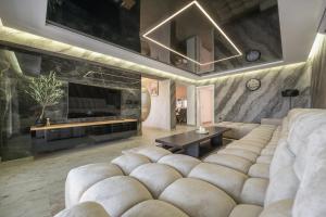 a living room with a large couch and a tv at Vila Lux in Tešanovića Mala