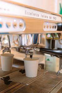 a coffee machine with cups sitting on a shelf at Zawaya Almasia Hotel 2 in Medina