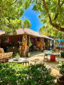 a house with a patio with a table and chairs at Canoa Roots Hostel & Camping in Canoa Quebrada