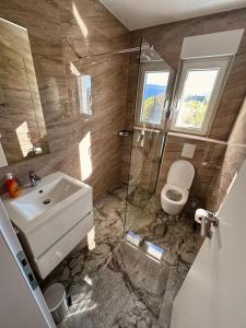 a bathroom with a sink and a toilet and a shower at Apartmani Jozić 2 in Ripci +12 photos