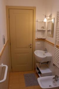 a bathroom with a white sink and a door at Ai tre camini in Adro