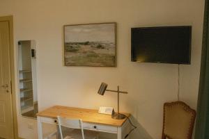 a room with a desk and a tv on the wall at Ai tre camini in Adro