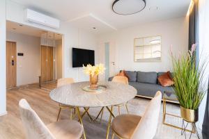 a living room with a table and a couch at Skylum 17th Floor Apartment in Vilnius