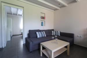 a living room with a blue couch and a table at Corfu Green Escape in Achílleion