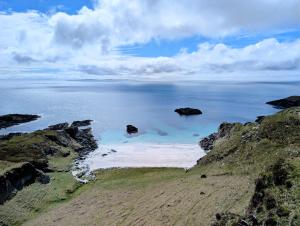 an aerial view of the ocean with rocks in the water at Scoor House - Laggan in Bunessan +4 photos