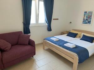 a bedroom with a bed and a couch and a window at Villa More in Pučišća
