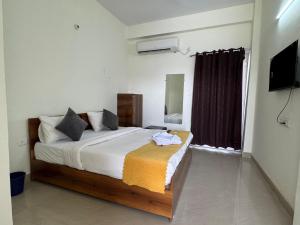 a bedroom with a bed and a television in it at Hotel Galaxy Inn in Greater Noida