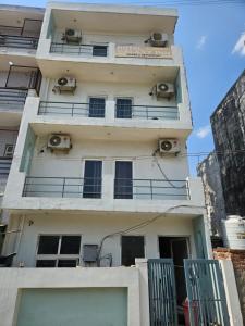 an apartment building with balconies and air conditioners at Hotel Galaxy Inn in Greater Noida