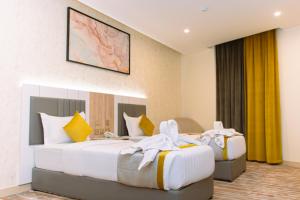 a hotel room with two beds with towels on them at Zawaya Almasia Hotel 2 in Medina +48 photos