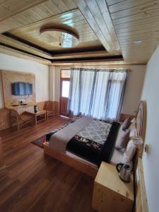 a bedroom with a bed and a table and a tv at The sky walk in Manāli