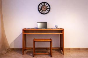 a desk with a laptop and a stool under a clock at Le Saint-Cyr Issoudun - Cosy, Spacious & Downtown in Issoudun