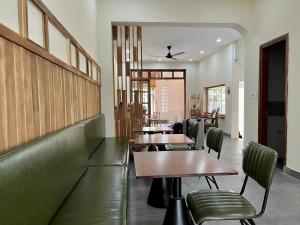 a restaurant with wooden tables and green chairs at Hue Sweethouse 2 Homestay in Hue