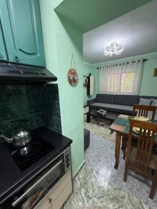 a kitchen with a stove and a living room at Sweet Escape in Shkodër