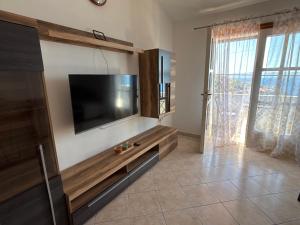 a living room with a flat screen tv on a wall at Winery Bačić in Blato