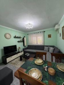 a living room with a table and a couch at Sweet Escape in Shkodër