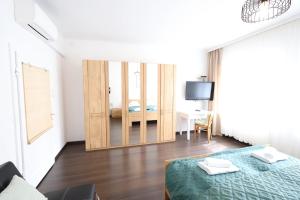 a bedroom with a bed and a desk and a television at Appartementhaus Ludwig in Mörbisch am See