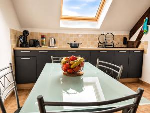 a kitchen with a table with a bowl of fruit on it at Le Saint-Cyr Issoudun - Cosy, Spacious & Downtown in Issoudun