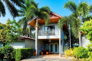 a house with palm trees in front of it at Neenlawat Riverside in Suratthani