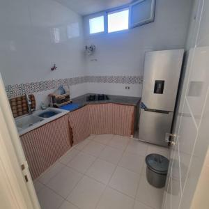 a small kitchen with a refrigerator and a sink at Maison à louer in Chebba