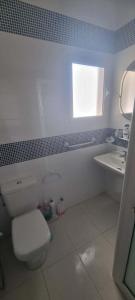 a bathroom with a white toilet and a sink at Maison à louer in Chebba +7 photos
