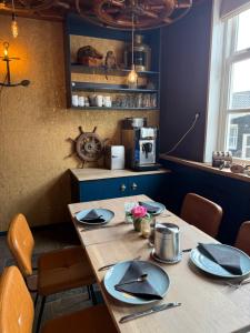 a table with plates and napkins on it in a kitchen at Hotel Restaurant de Boekanier in Vrouwenpolder +42 photos