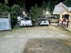 two cars parked in front of a house at night at CM Star Suites - Guesthouse in Vigan