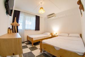 a hotel room with two beds and a window at Bohem Pansiyon in Kuşadası