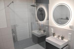 ein Badezimmer mit Waschbecken und Spiegel in der Unterkunft Ferienwohnung Ullrichshof Oberlausitz - Sauna Grillplatz Panoramablick in Malschwitz + 28 Fotos