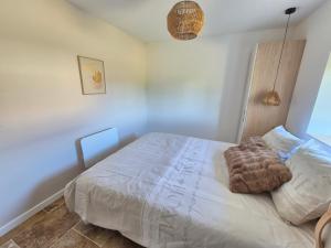a bedroom with a white bed with a brown blanket at La P'tite Pierre in Ineuil