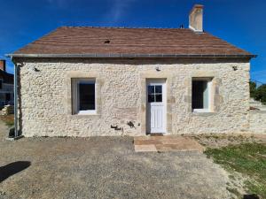 a stone house with a white door and windows at La P'tite Pierre in Ineuil