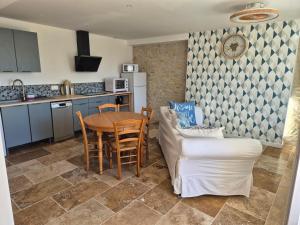 a kitchen and living room with a table and chairs at La P'tite Pierre in Ineuil