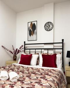 a bedroom with a bed with red pillows and a clock at Hotel Sara & SPA in Prishtinë +45 photos