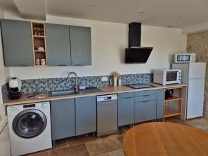 a kitchen with a sink and a washer and dryer at La P'tite Pierre in Ineuil +4 photos
