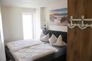 ein Schlafzimmer mit einem Bett mit weißer Bettwäsche und einem Fenster in der Unterkunft Ferienwohnung Ullrichshof Oberlausitz - Sauna Grillplatz Panoramablick in Malschwitz