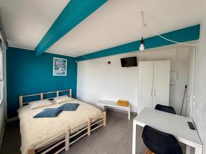 a bedroom with a bed and a blue wall at Ô Bord de Mer ! in Hyères